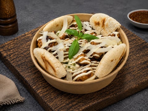 Bowl of Vietnamese banh mi sandwich with shredded vegetables, cilantro, and meat on a wooden serving board